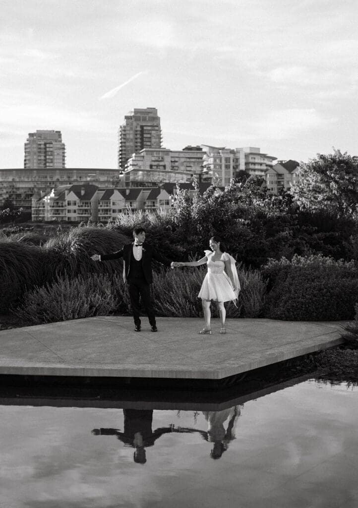 couple dancing on the pond outside of laurel point inn, their reflection in the pond