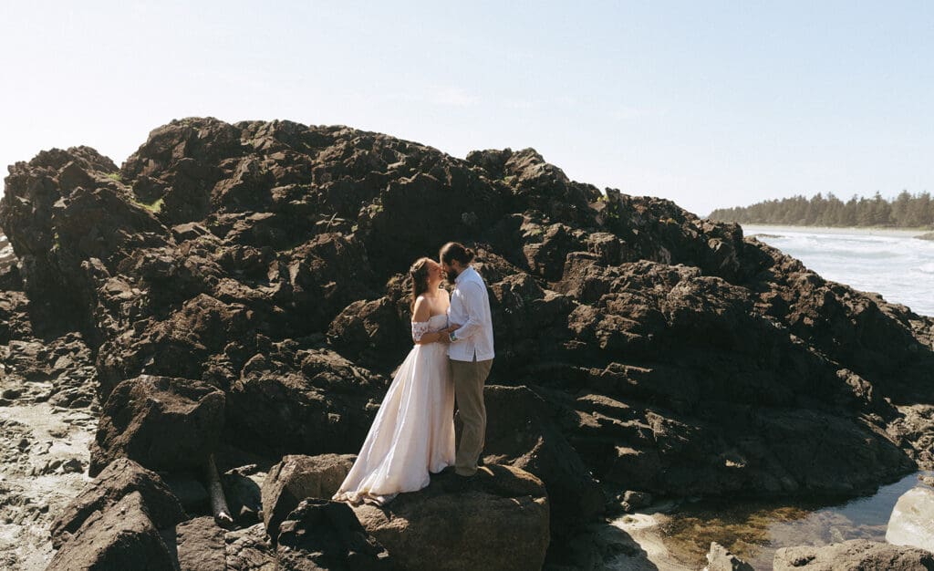 Newlyweds share a kiss on the beach at their  elopement in tofino bc