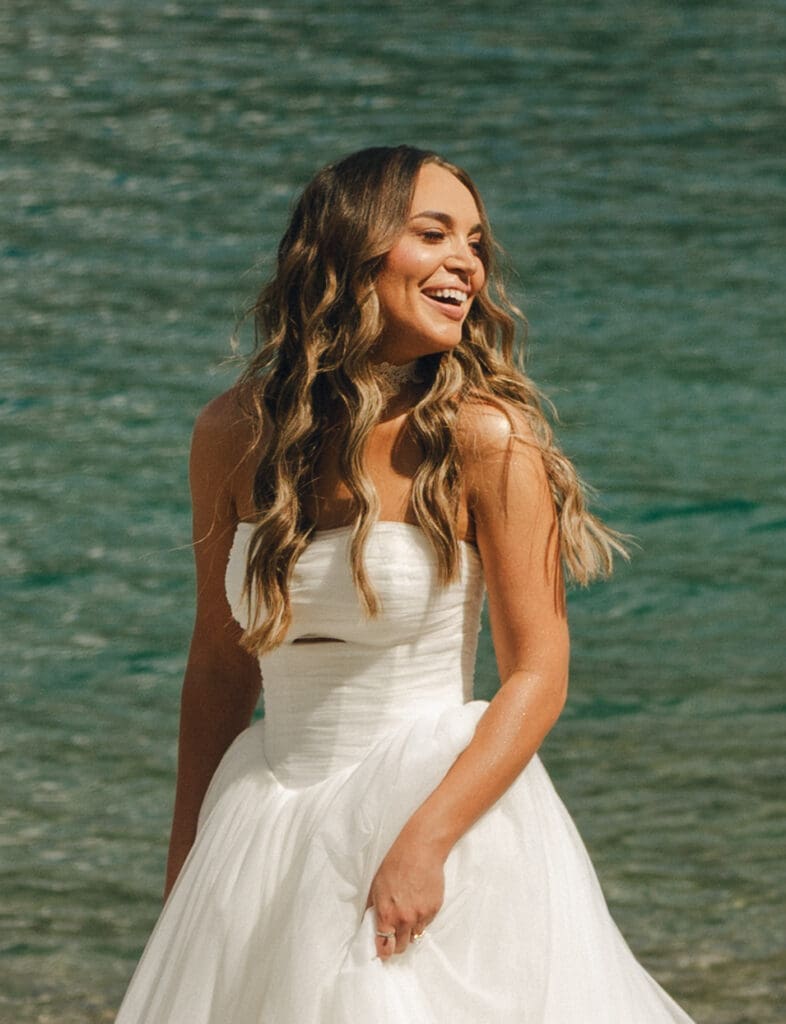 An American bride is photographed next to the water at Lake Moraine before her destination Banff wedding 