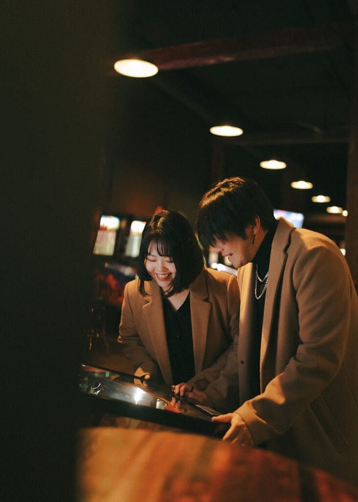 A couple play arcade games during an engagement photoshoot vancouver island