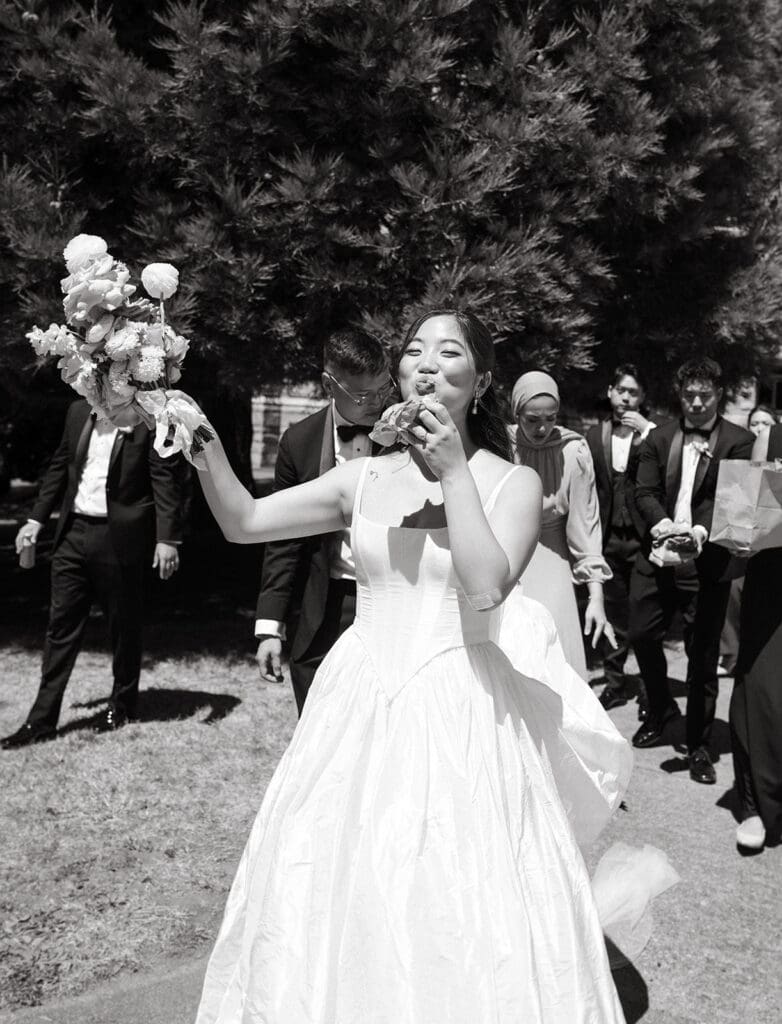 A bride enjoys McDonald's in a b+w photo taken before her inn at laurel point wedding