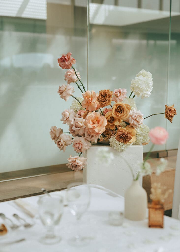Summer inspired florals in soft creams and pinks are photographed at an inn at laurel point wedding reception