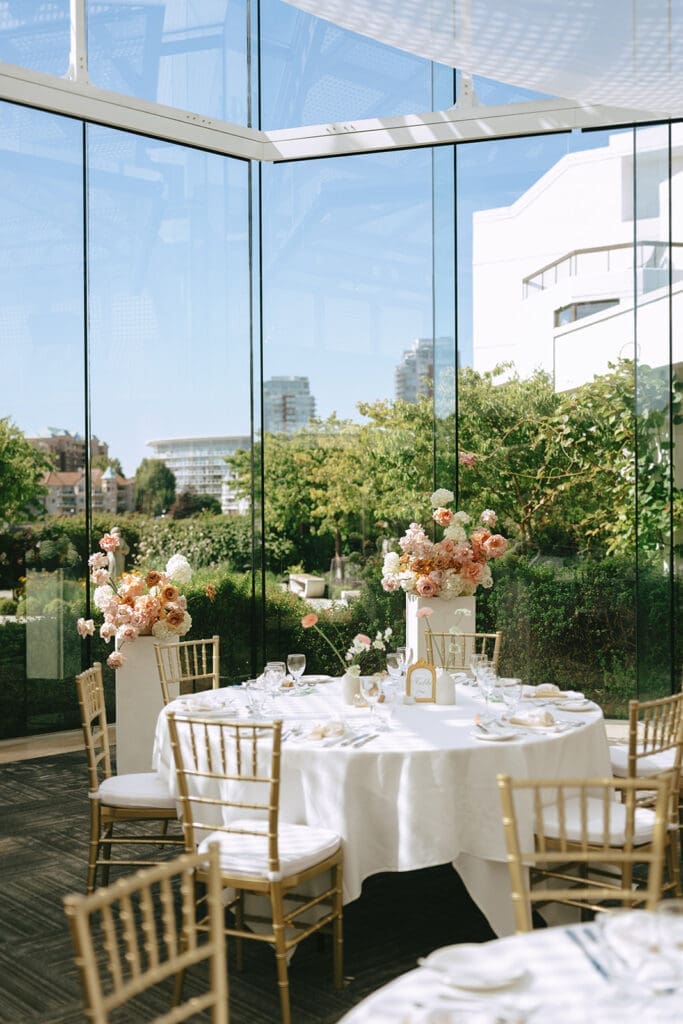 A table featuring summer inspired florals is photographed at a laurel point inn wedding reception