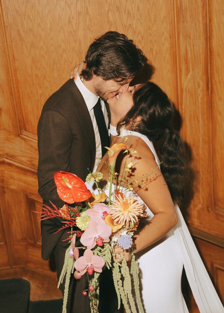 Newlyweds share a kiss in a bridal portrait captured at a hatley park wedding in Victoria BC