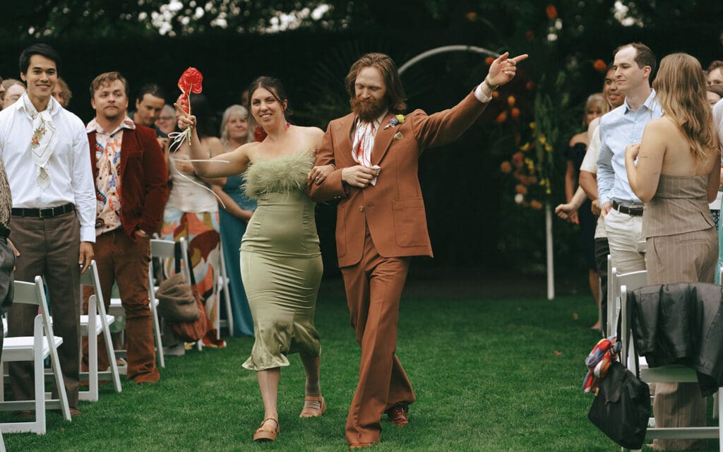 Bridal party members celebrate as they walk down the aisle following a Hatley Castle wedding 