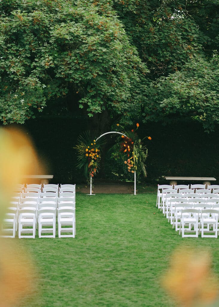 Guest seating and a floral covered arch is photographed at a Hatley Park wedding 