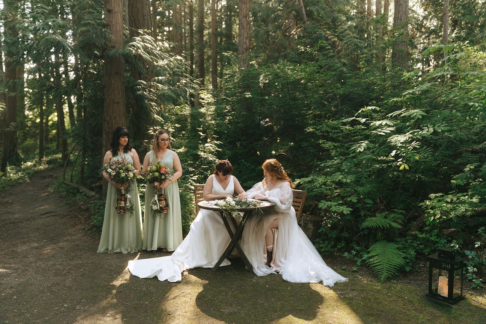 Brides sign marriage license at their forest ceremony at Sea Cider on Vancouver Island