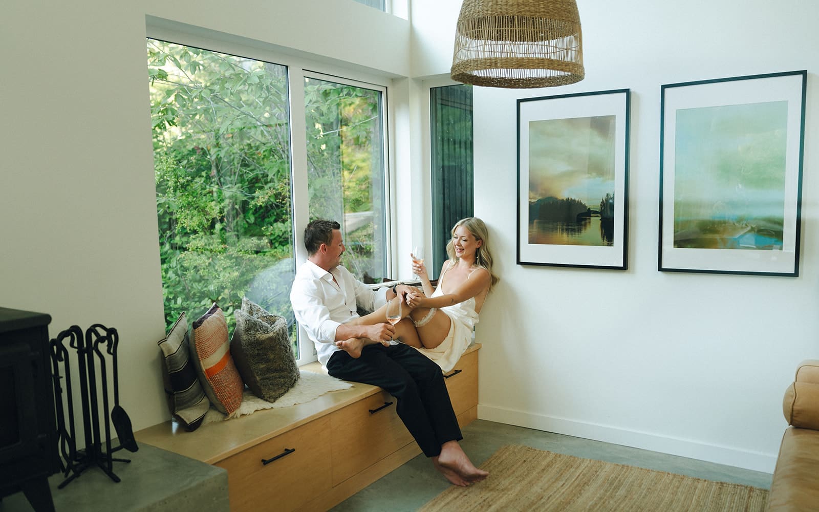 Bride has her legs up on groom's lap by the window inside airbnb in Tofino